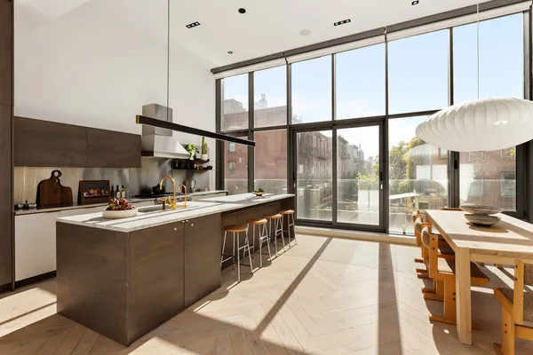 a view of a kitchen with kitchen island a large window a sink and stainless steel appliances