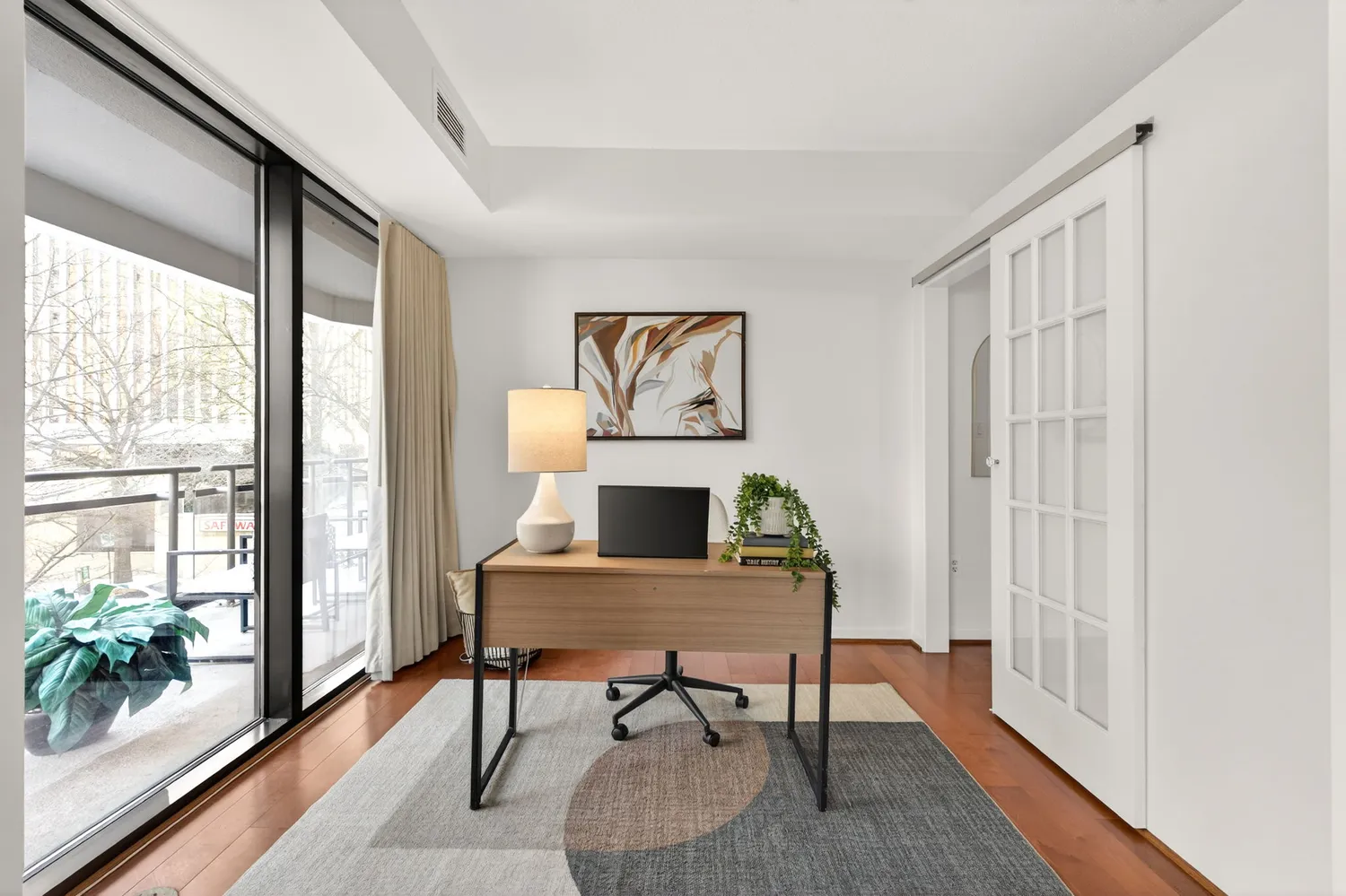 a view of a workspace with furniture and a window