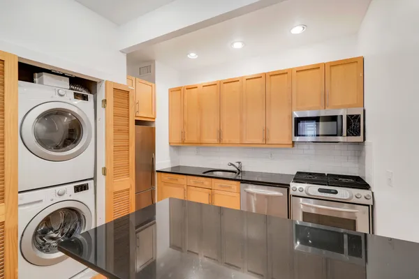 a kitchen with stainless steel appliances granite countertop a sink a stove and a microwave