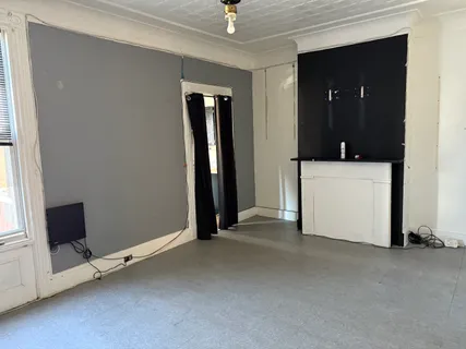 a view of a room with a flat tv screen and a ceiling fan