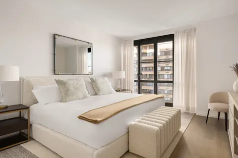 a bedroom with a bed and a large window