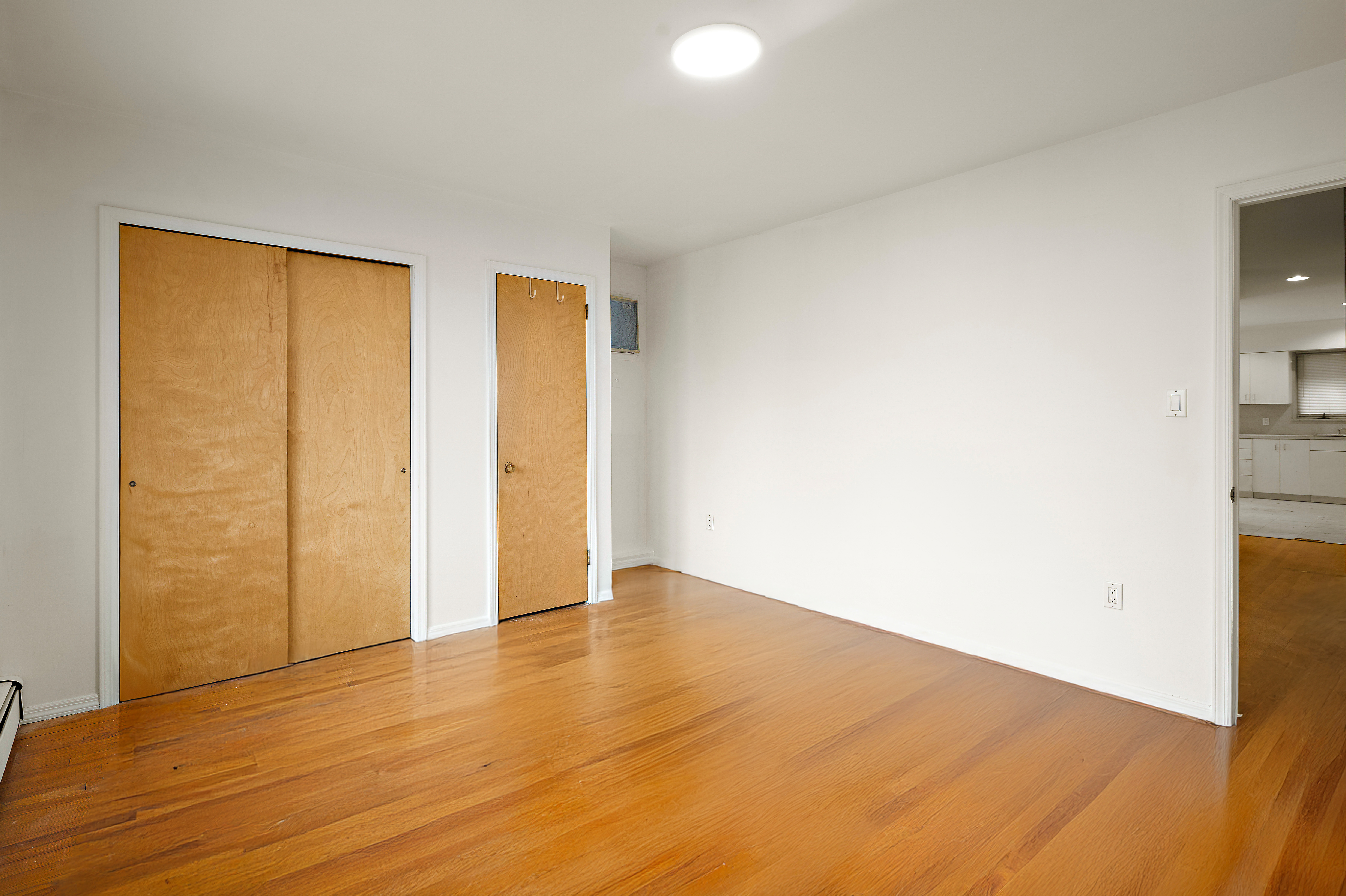 558 84th Street Brooklyn, NY 11209 - Photo 16 of 25 a view of an empty room with wooden floor and a window