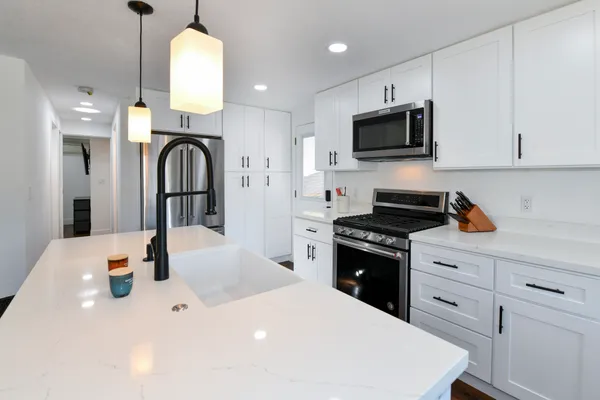 a kitchen with stainless steel appliances a stove microwave and sink