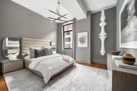 a bedroom with a bed and a chandelier