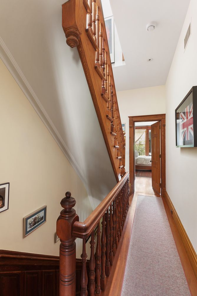 a view of a hallway with wooden floor and staircase