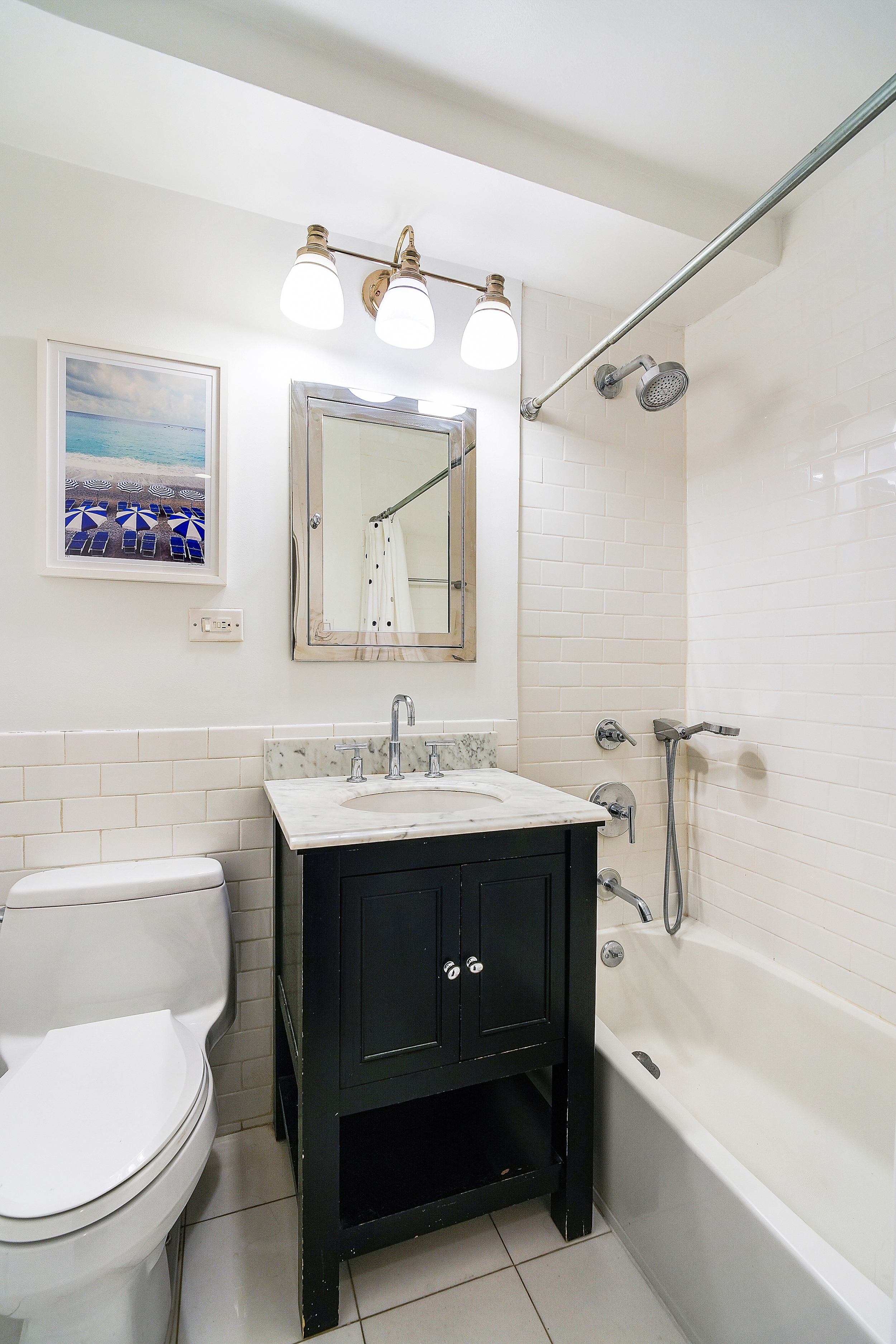 241 East 76th Street, Unit 2G Manhattan, NY 10021 - Photo 7 of 11 a bathroom with a toilet sink and mirror