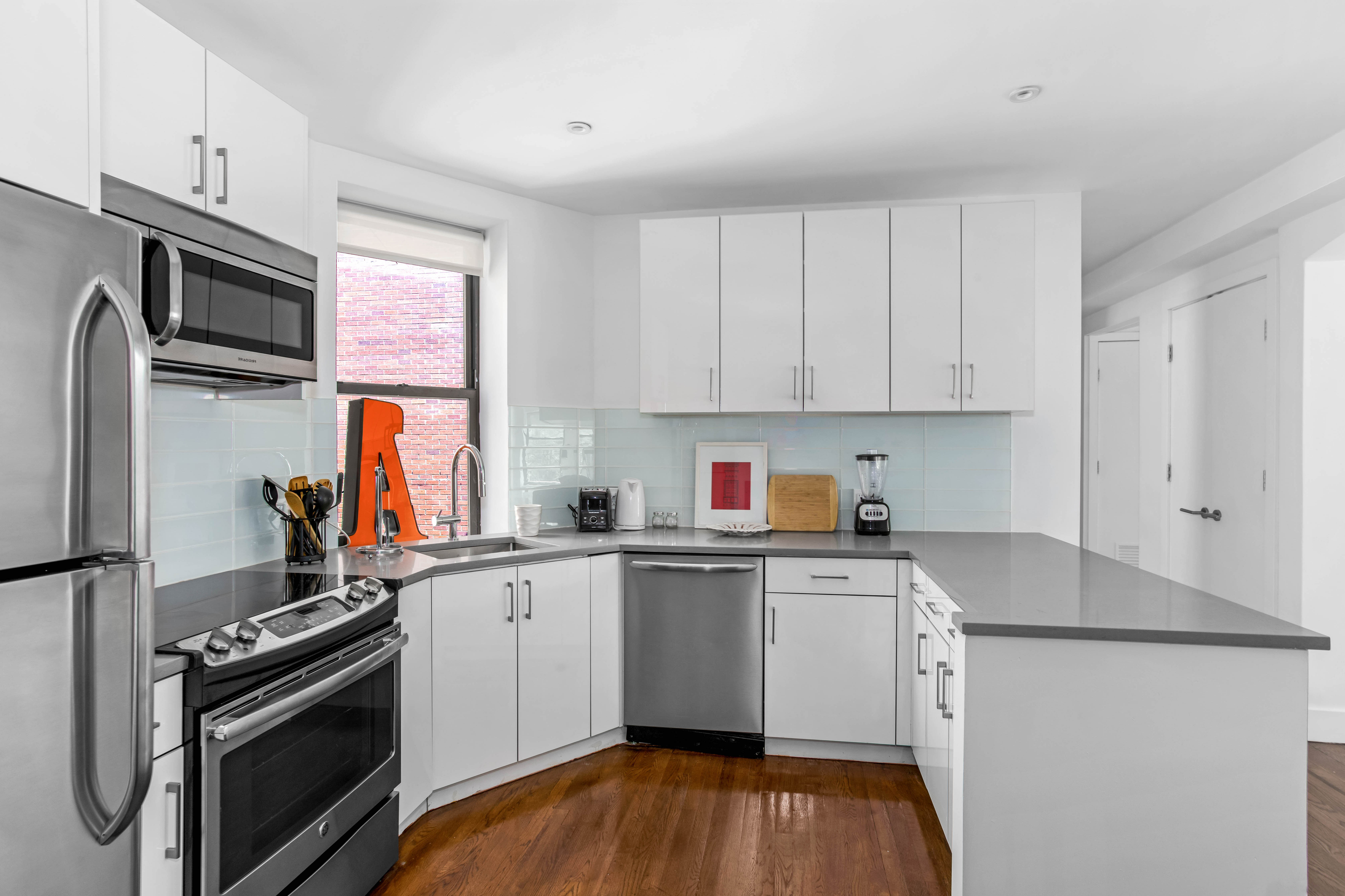 245 West 25th Street, Unit PHD Manhattan, NY 10001 - Photo 3 of 16 a kitchen with stainless steel appliances a sink cabinets and a wooden floor