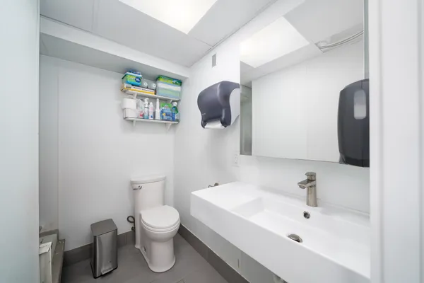 a bathroom with a toilet sink and mirror