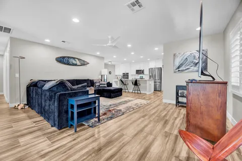 a living room with furniture a wooden floor and chandelier