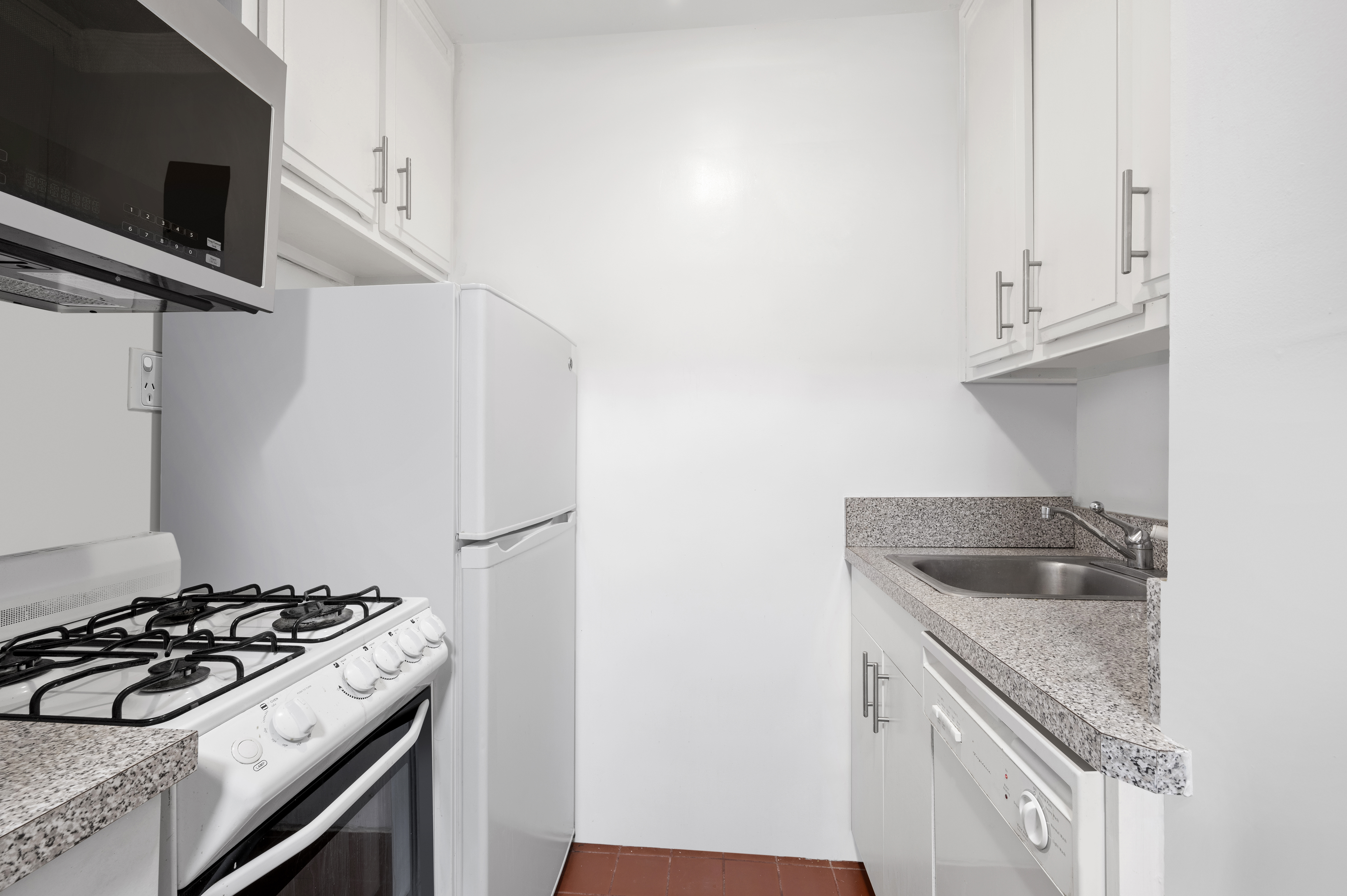 61 Jane Street, Unit 5A Manhattan, NY 10014 - Photo 5 of 13 a kitchen with granite countertop a sink stove and refrigerator