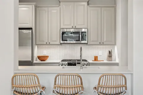 a kitchen with stainless steel appliances a stove a microwave a refrigerator and cabinets