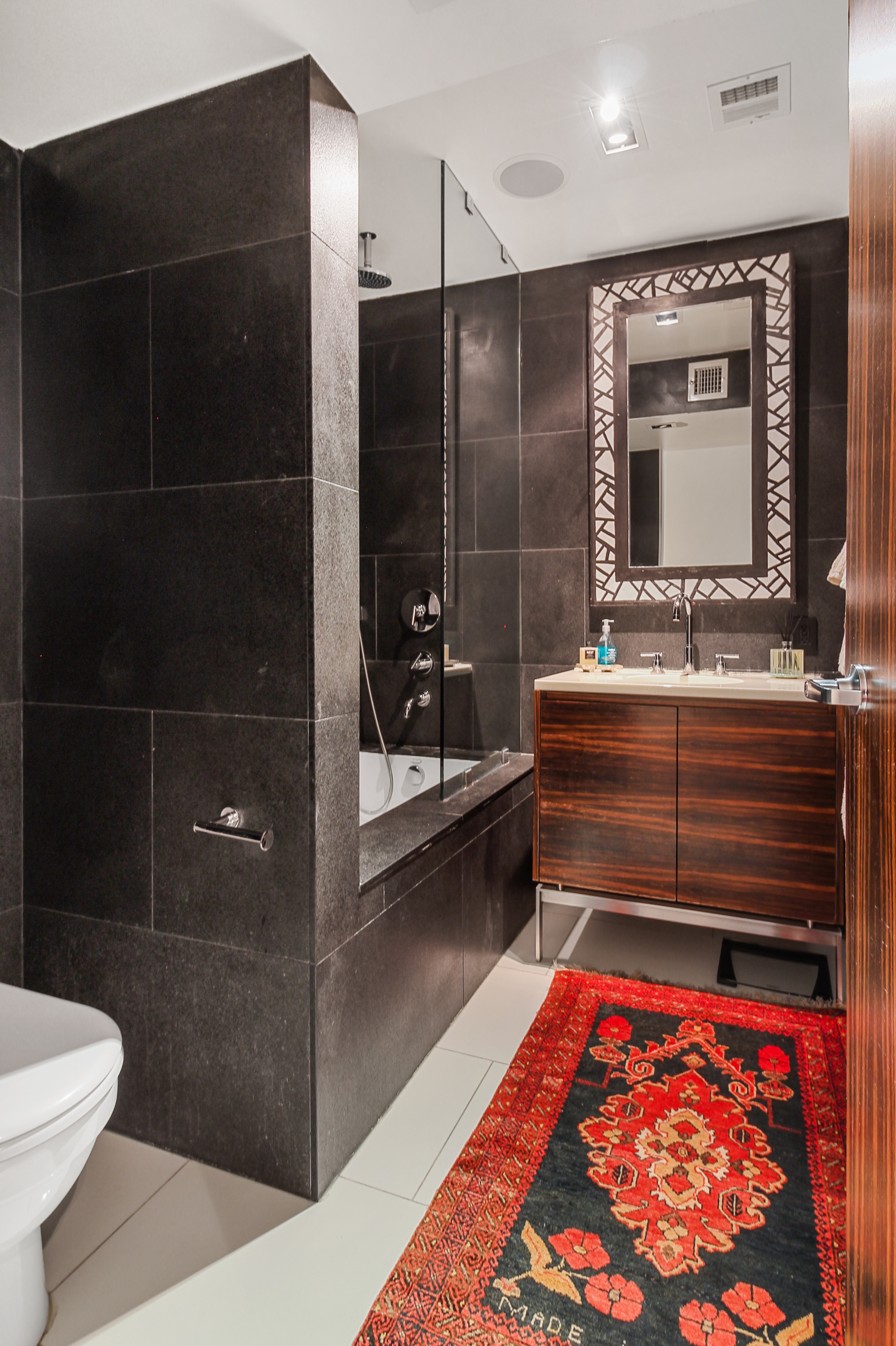 405 Broadway, Unit 4 Manhattan, NY 10013 - Photo 17 of 19 a bathroom with a double vanity sink a toilet and shower