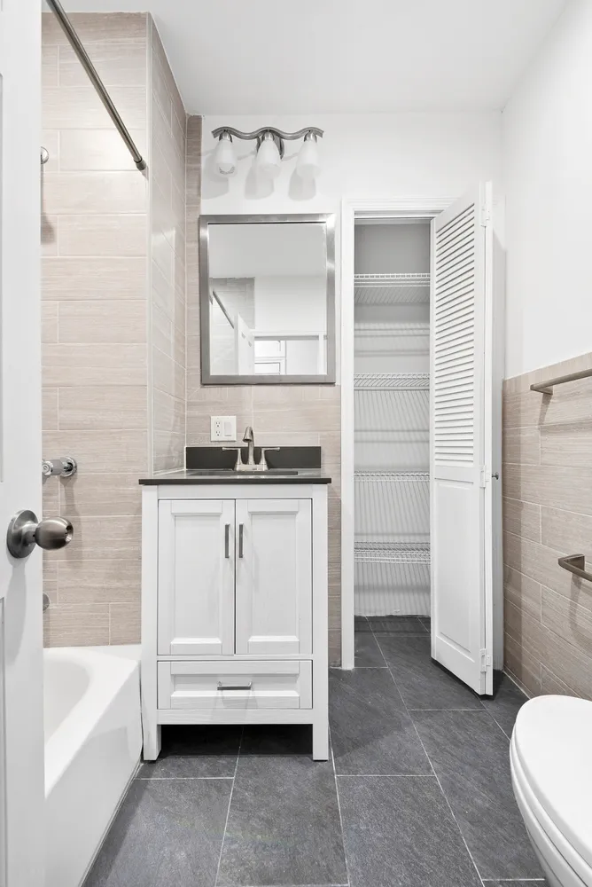 a bathroom with a granite countertop sink toilet and bathtub