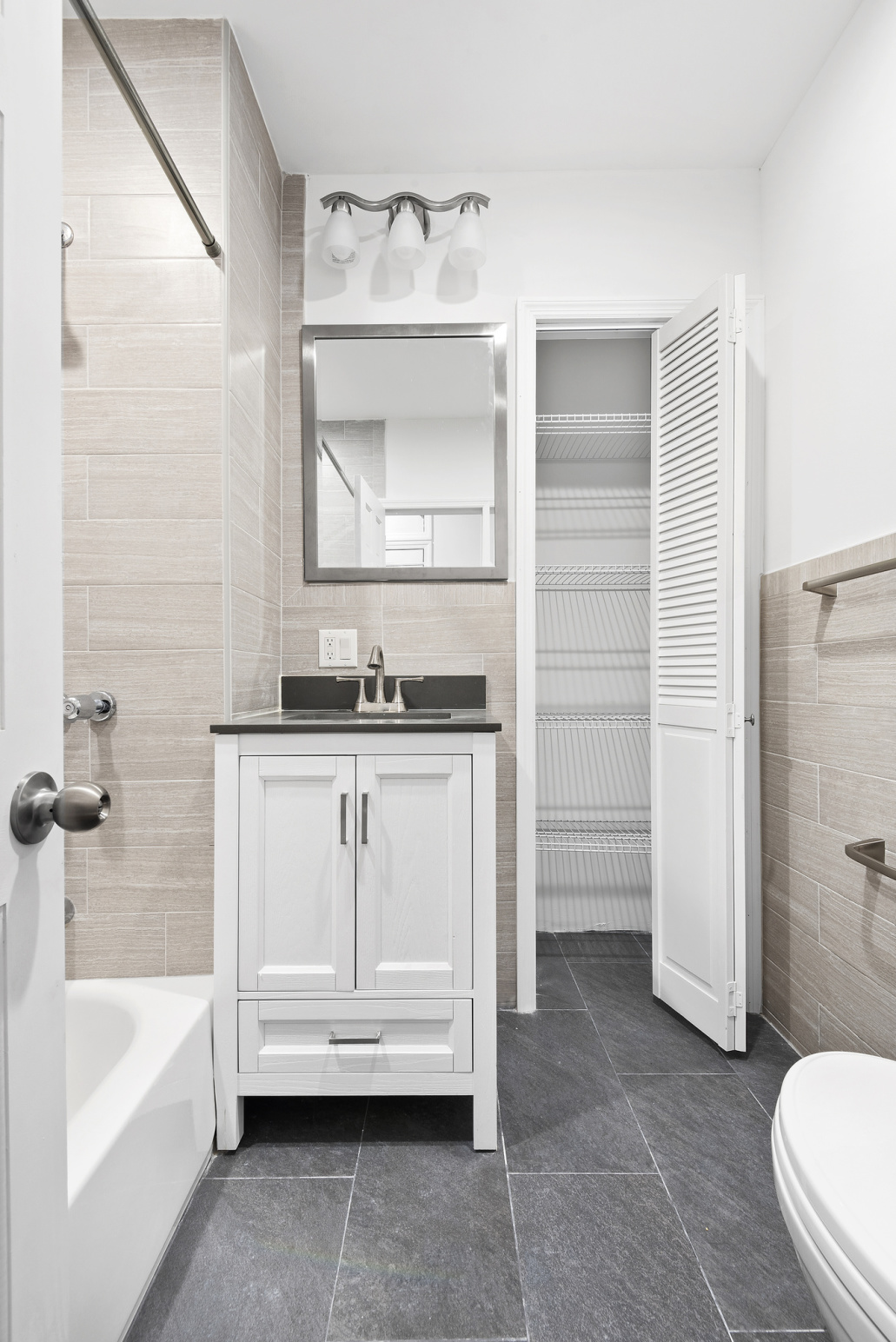 573 6th Street, Unit 1 Brooklyn, NY 11215 - Photo 8 of 10 a bathroom with a granite countertop sink toilet and bathtub