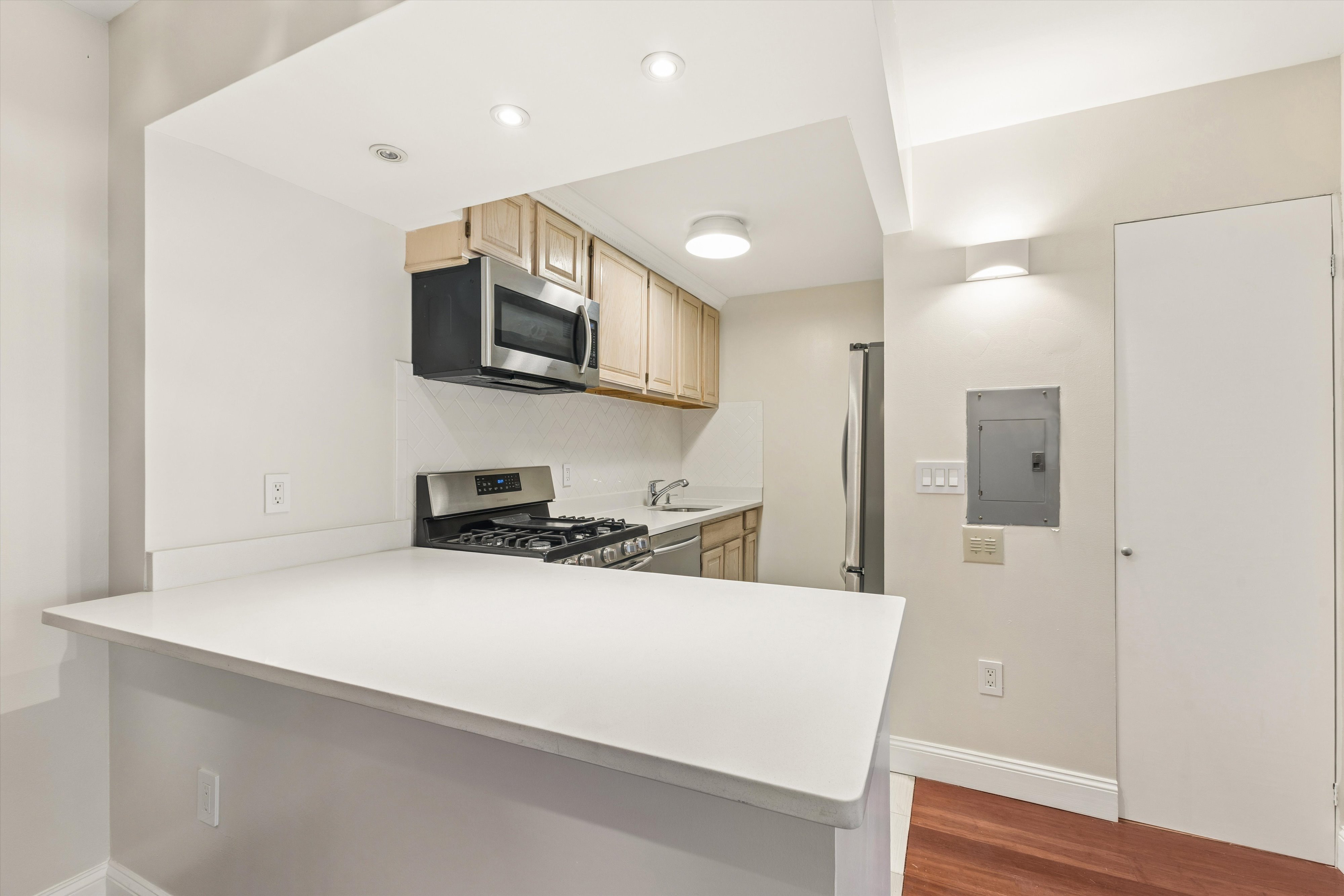 1919 Madison Avenue, Unit 418 Manhattan, NY 10035 - Photo 5 of 16 a kitchen with stainless steel appliances a microwave a sink and a refrigerator