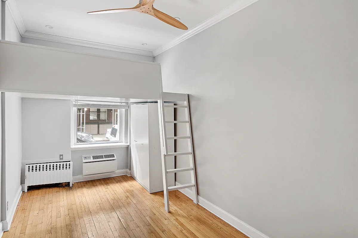 521 East 81st Street, Unit B Manhattan, NY 10028 - Photo 2 of 5 a view of an empty room with wooden floor and a window