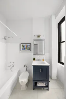 a bathroom with a toilet sink vanity tub and mirror