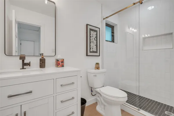 a bathroom with a toilet a sink and mirror