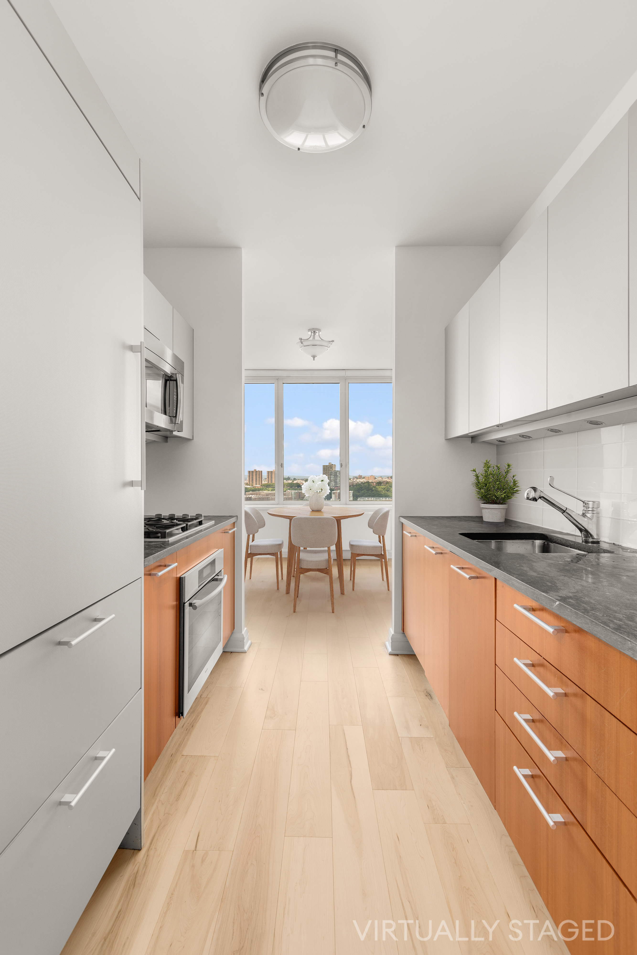100 Riverside Boulevard, Unit 29C Manhattan, NY 10069 - Photo 5 of 15 a large white kitchen with stainless steel appliances granite countertop a sink dishwasher a stove and a refrigerator with wooden floor