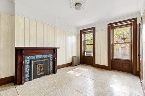 an empty room with windows and fireplace