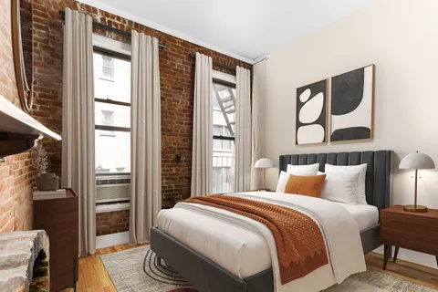 a bedroom with a bed and a large window