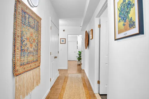 a view of a hallway with wooden floor and windows