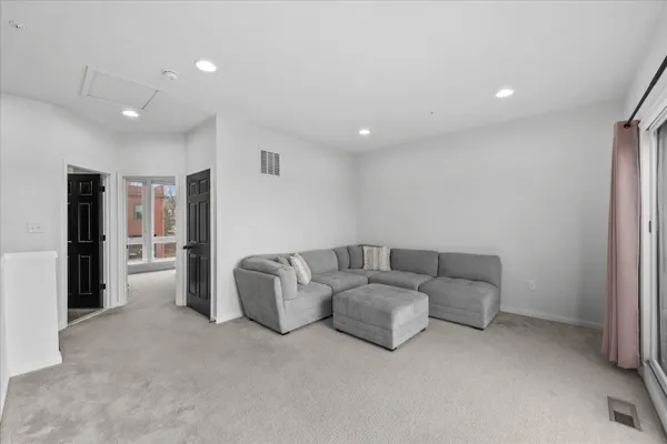 a living room with furniture and a refrigerator