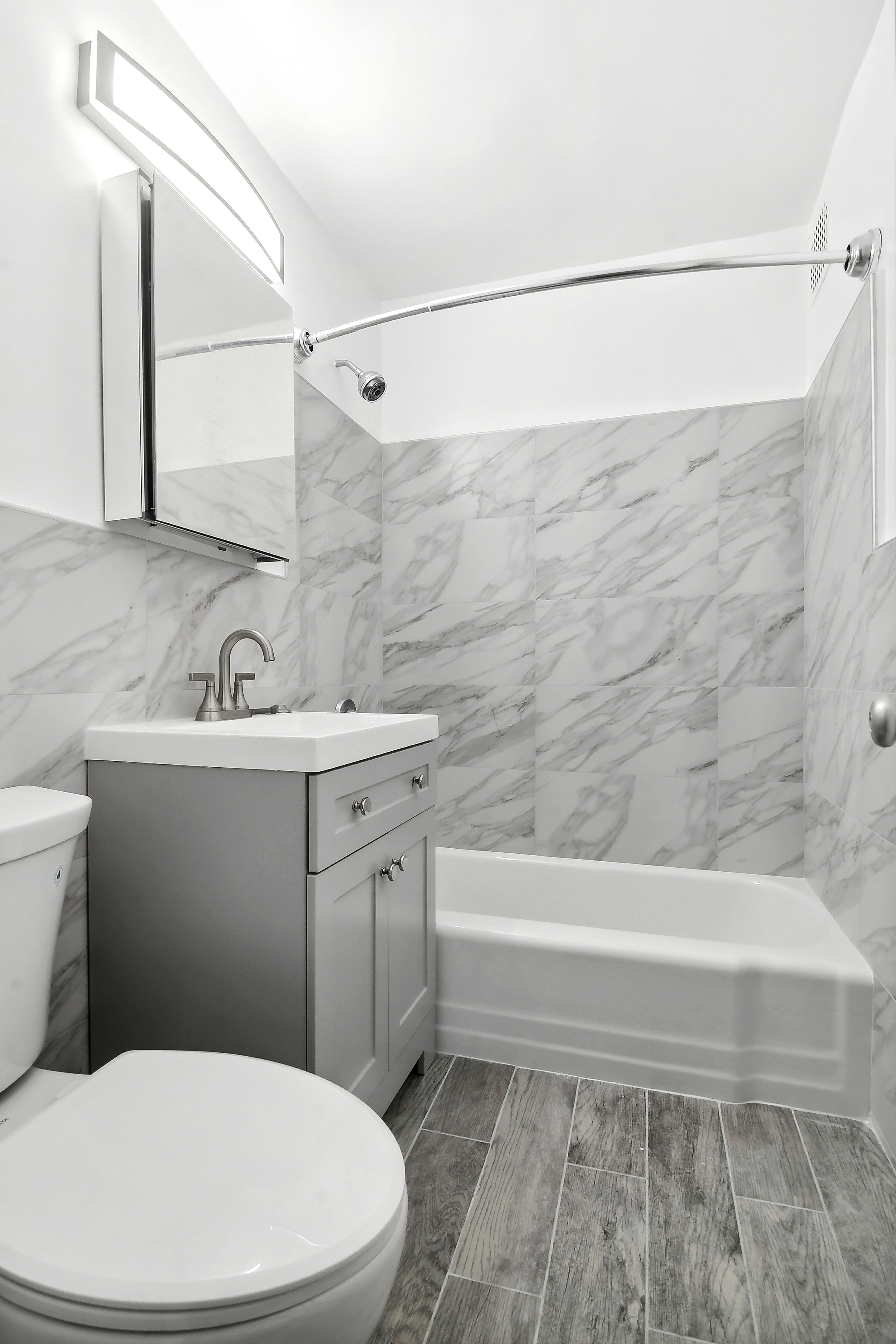 185 Hall Street, Unit 1009 Brooklyn, NY 11205 - Photo 3 of 5 a bathroom with a sink a mirror and a toilet