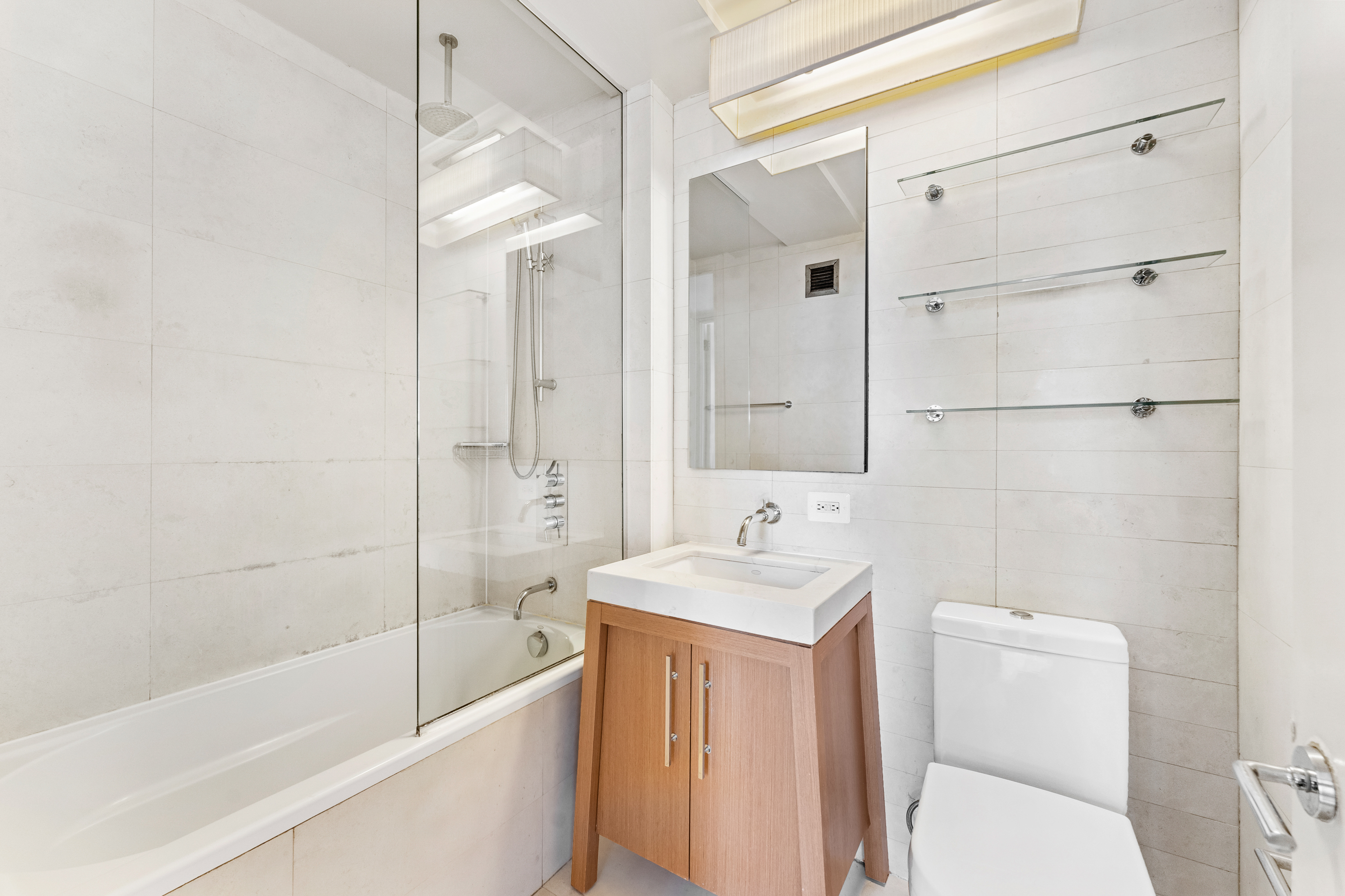 88 Greenwich Street, Unit 1212 Manhattan, NY 10006 - Photo 3 of 10 a bathroom with a sink a toilet and shower