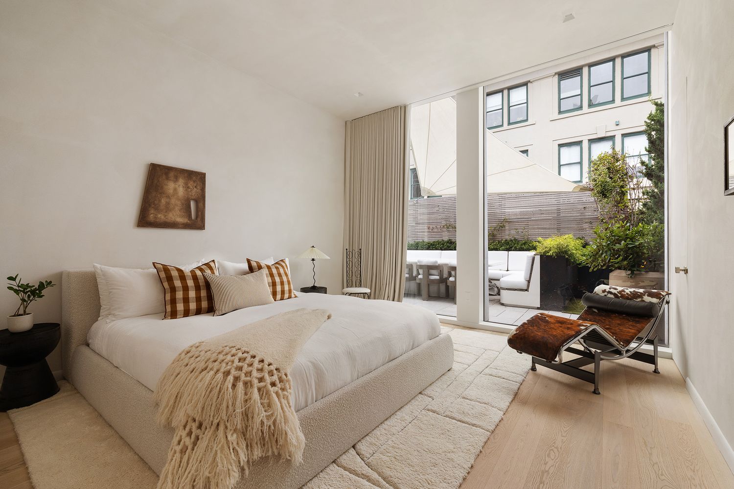 a bedroom with a bed a large window and chair