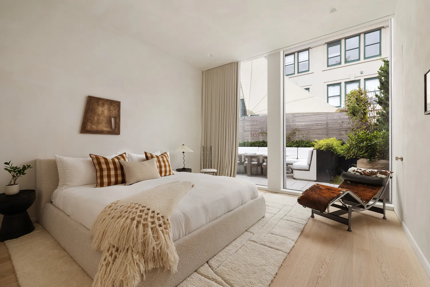 a bedroom with a bed a large window and chair