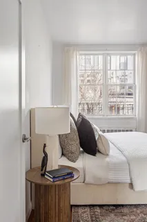 a bedroom with a bed and a large window