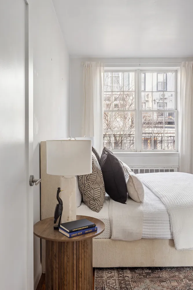 a bedroom with a bed and a large window