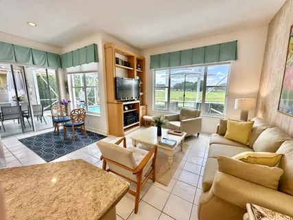 a living room with furniture large window and a table