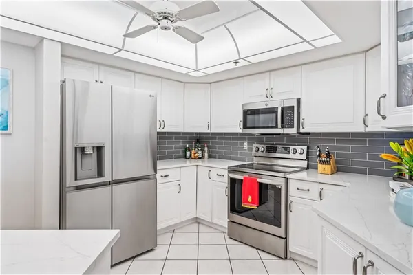 a kitchen with stainless steel appliances granite countertop a refrigerator a stove top oven a sink and cabinets