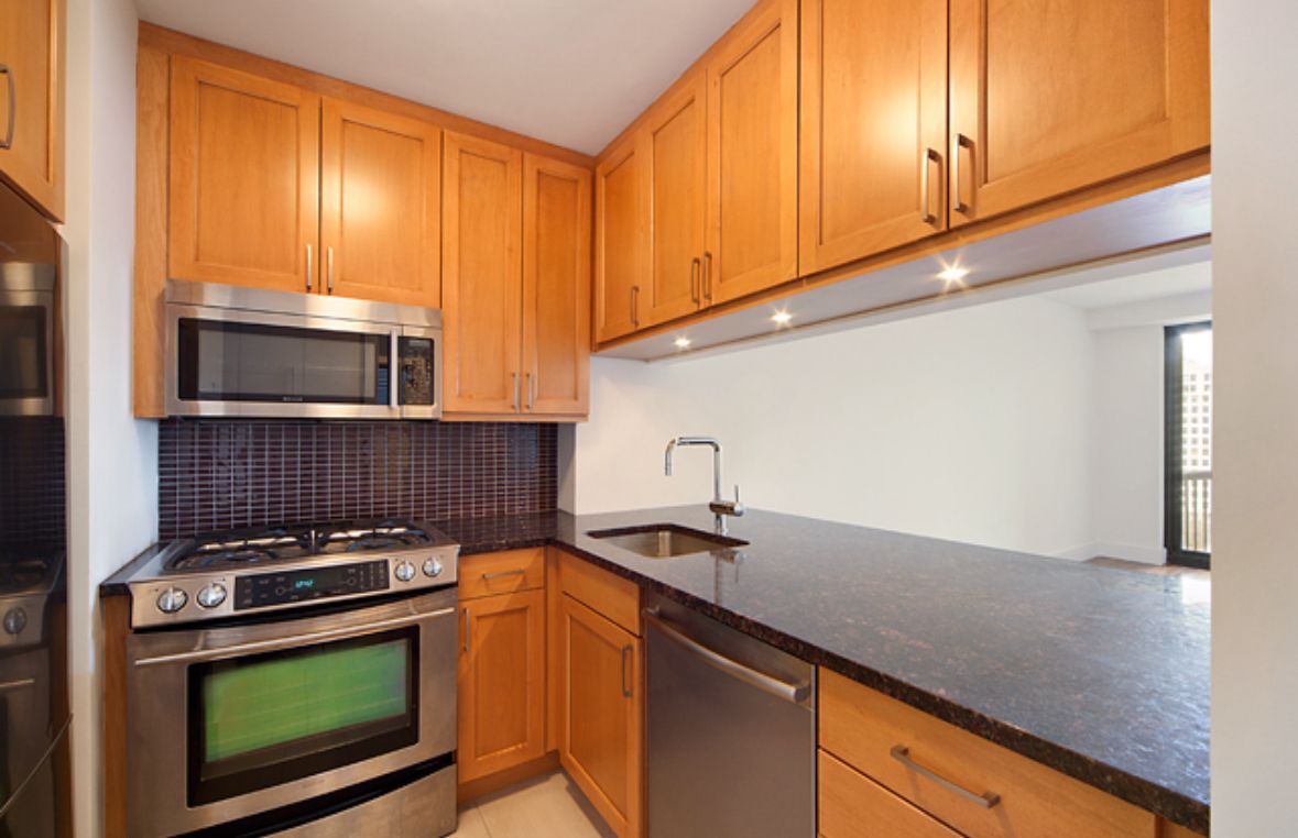 45 East 25th Street, Unit 16A Manhattan, NY 10010 - Photo 3 of 6 a kitchen with stainless steel appliances granite countertop a stove a sink and a microwave