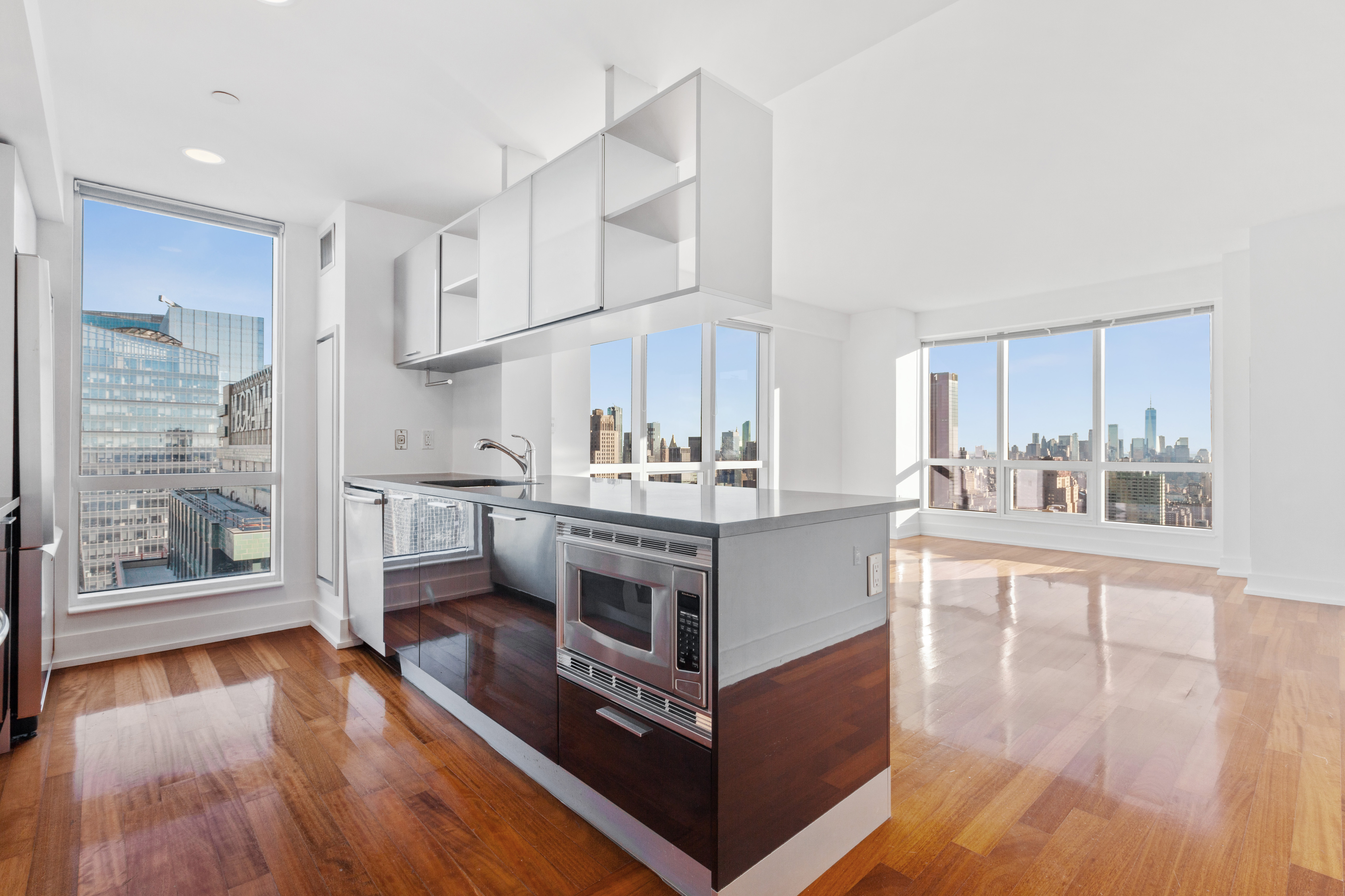 350 West 42nd Street, Unit 48E Manhattan, NY 10036 - Photo 4 of 17 a kitchen with stainless steel appliances granite countertop a lot of counter space and wooden floors