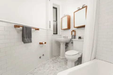 a bathroom with a toilet sink and mirror
