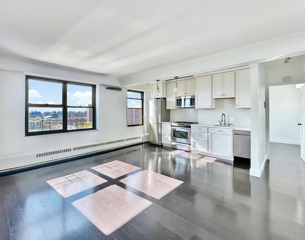 a kitchen with stainless steel appliances granite countertop a stove a refrigerator a sink a dining table and chairs with wooden floor