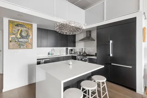 a kitchen with stainless steel appliances a sink a table and chairs