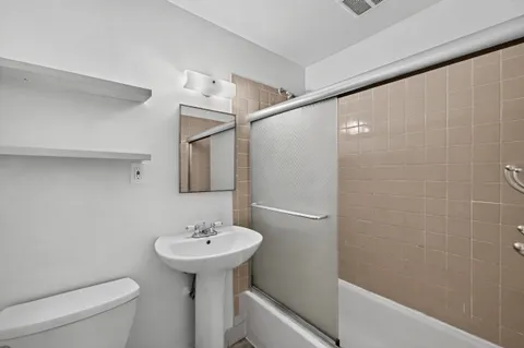 a bathroom with a sink toilet and shower