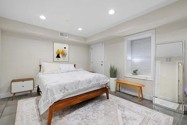 a bedroom with a bed and painting on the wall