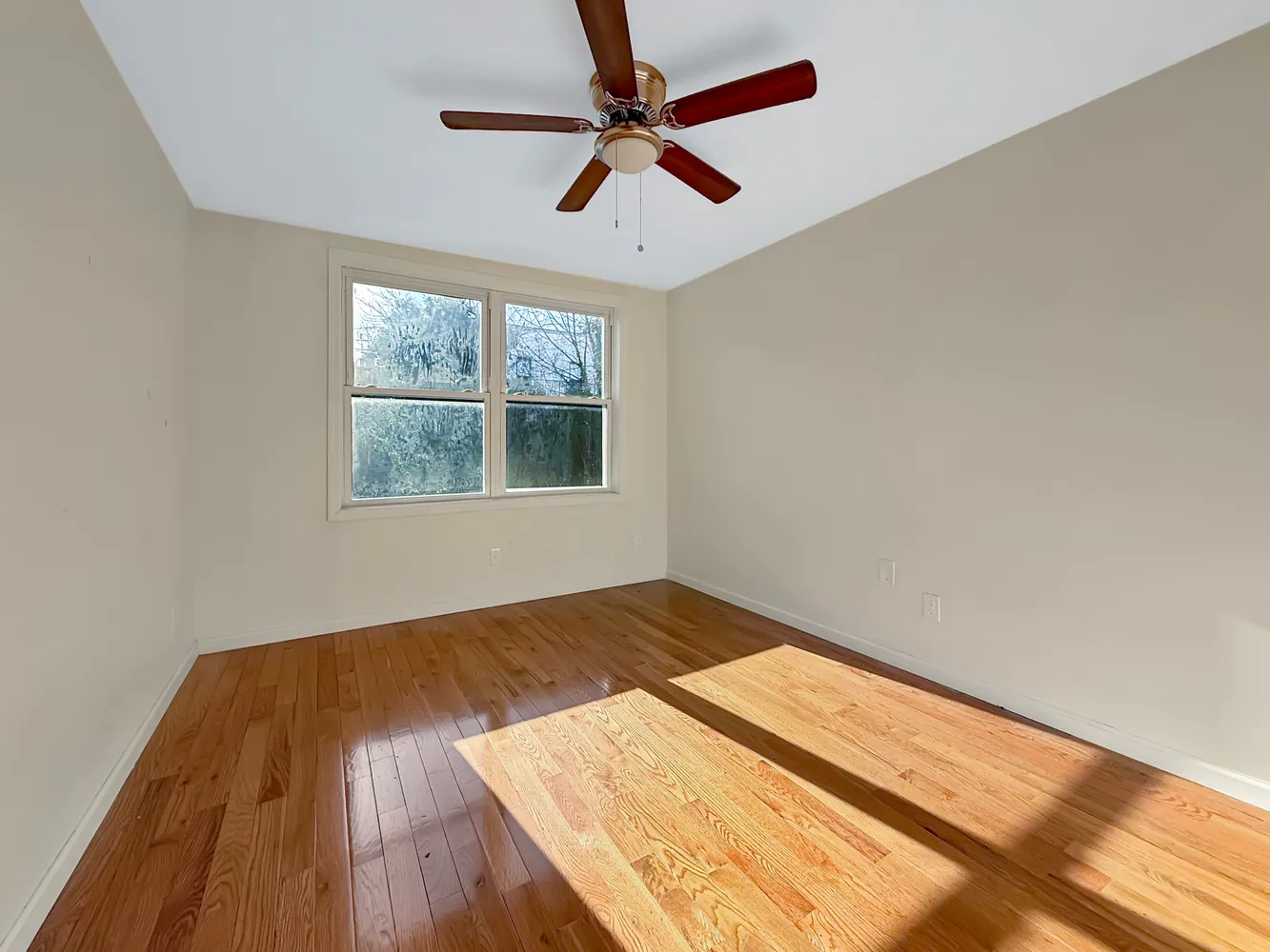 wooden floor in an empty room with a window