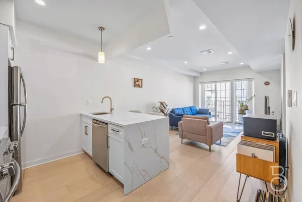 a view of living room with stainless steel appliances furniture and a window