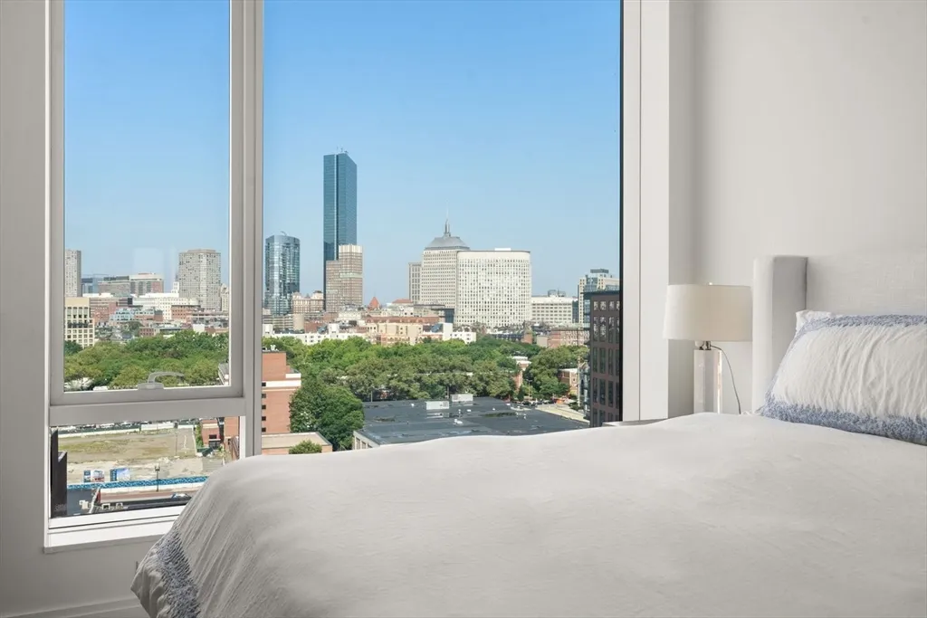 a bedroom with a bed and a large window