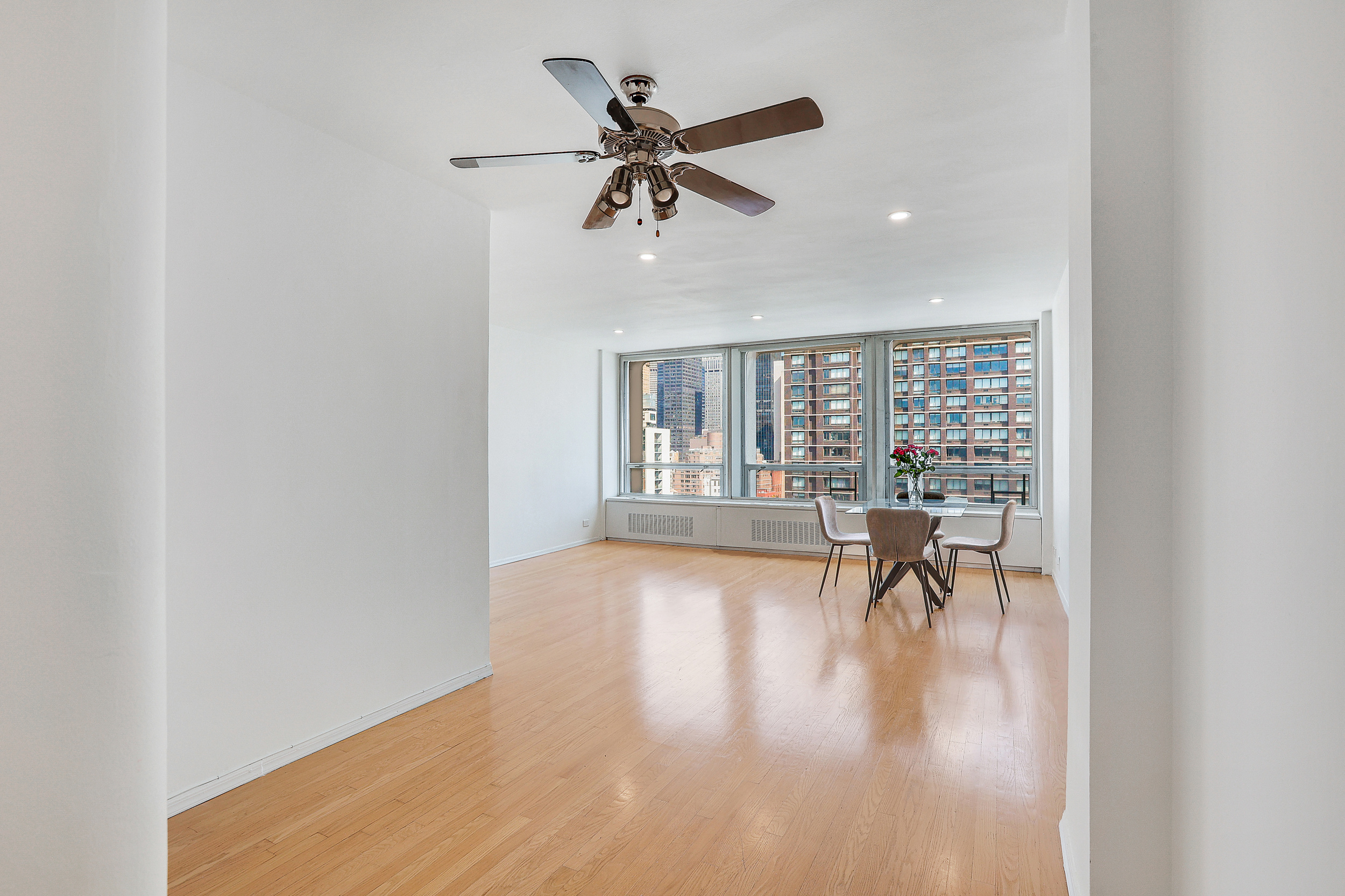 300 East 33rd Street, Unit 21K Manhattan, NY 10016 - Photo 5 of 17 a view of a livingroom with wooden floor and a ceiling fan