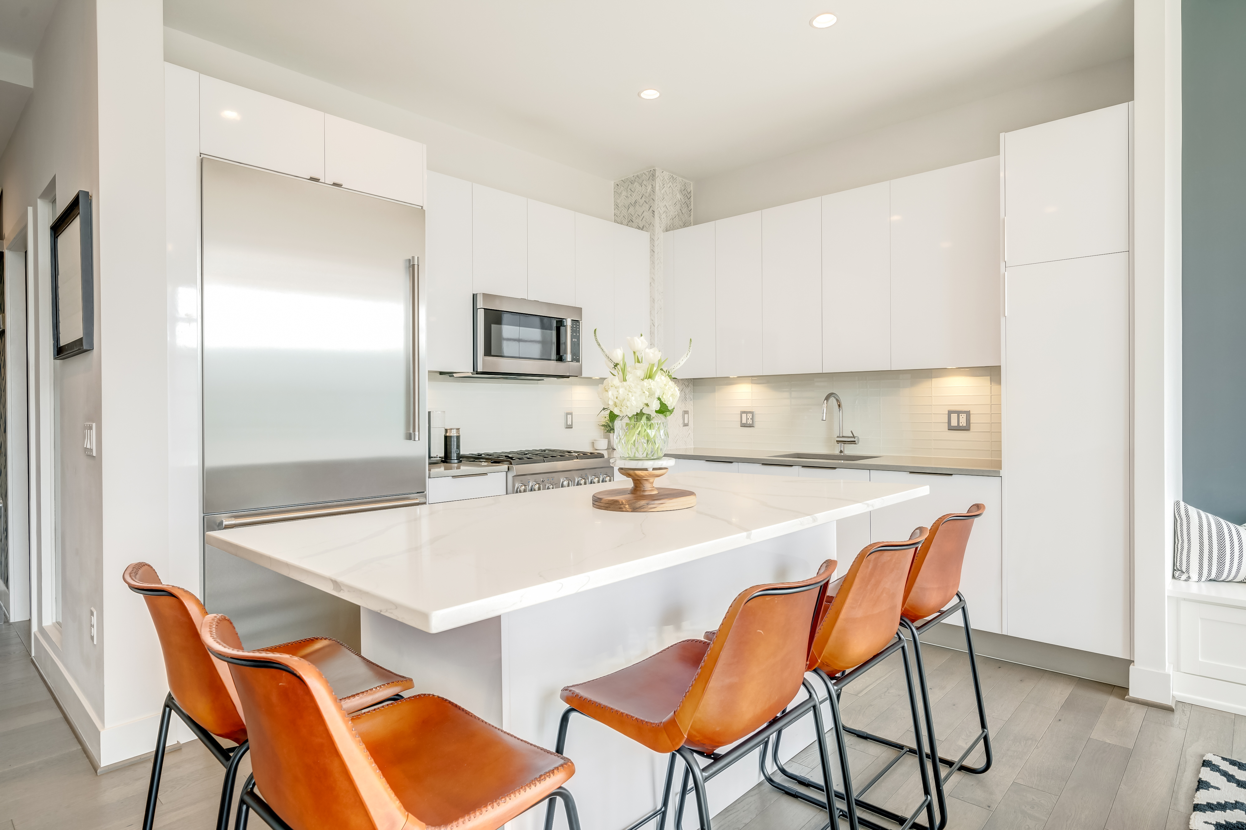 45 Sutton Square Southwest, Unit PH10 Washington, DC 20024 - Photo 15 of 44 a kitchen with a dining table chairs and a refrigerator
