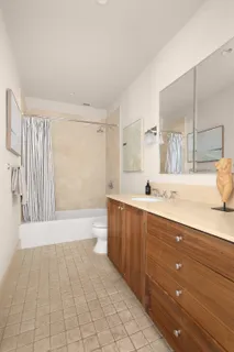 a spacious bathroom with a vanity a mirror a bathtub and shower