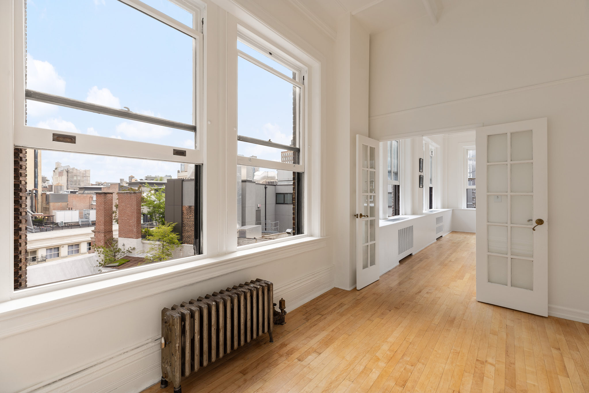 874 Broadway, Unit 907 Manhattan, NY 10003 - Photo 6 of 22 a view of a hallway with wooden floor and windows