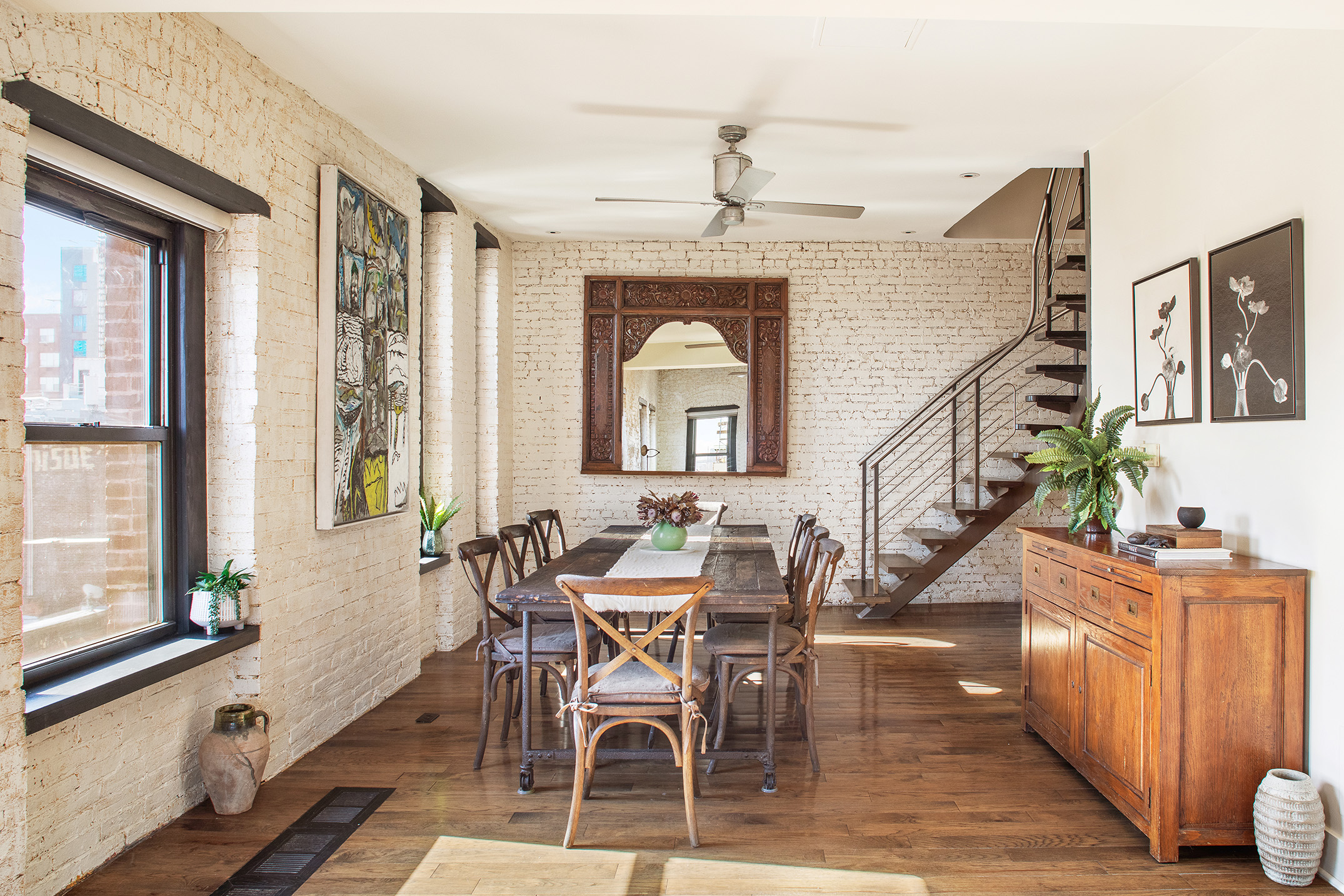a dining room with wooden floor a chandelier a wooden table and chairs